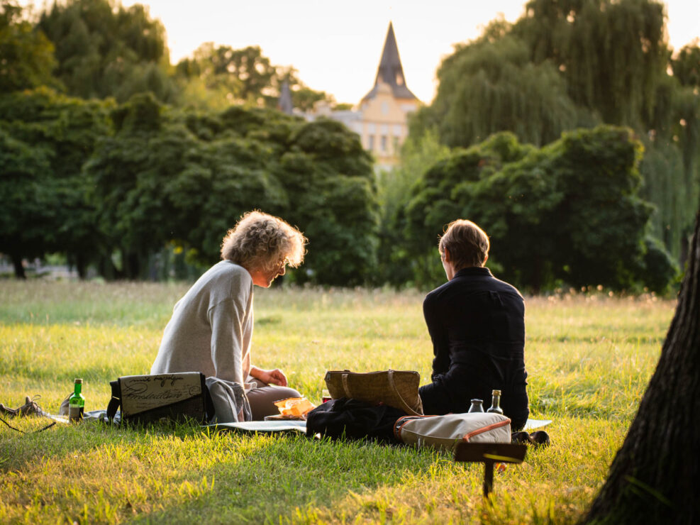 Zwei Frauen beim Picknick in der Abendsonne vor Schloß Liebenberg.
